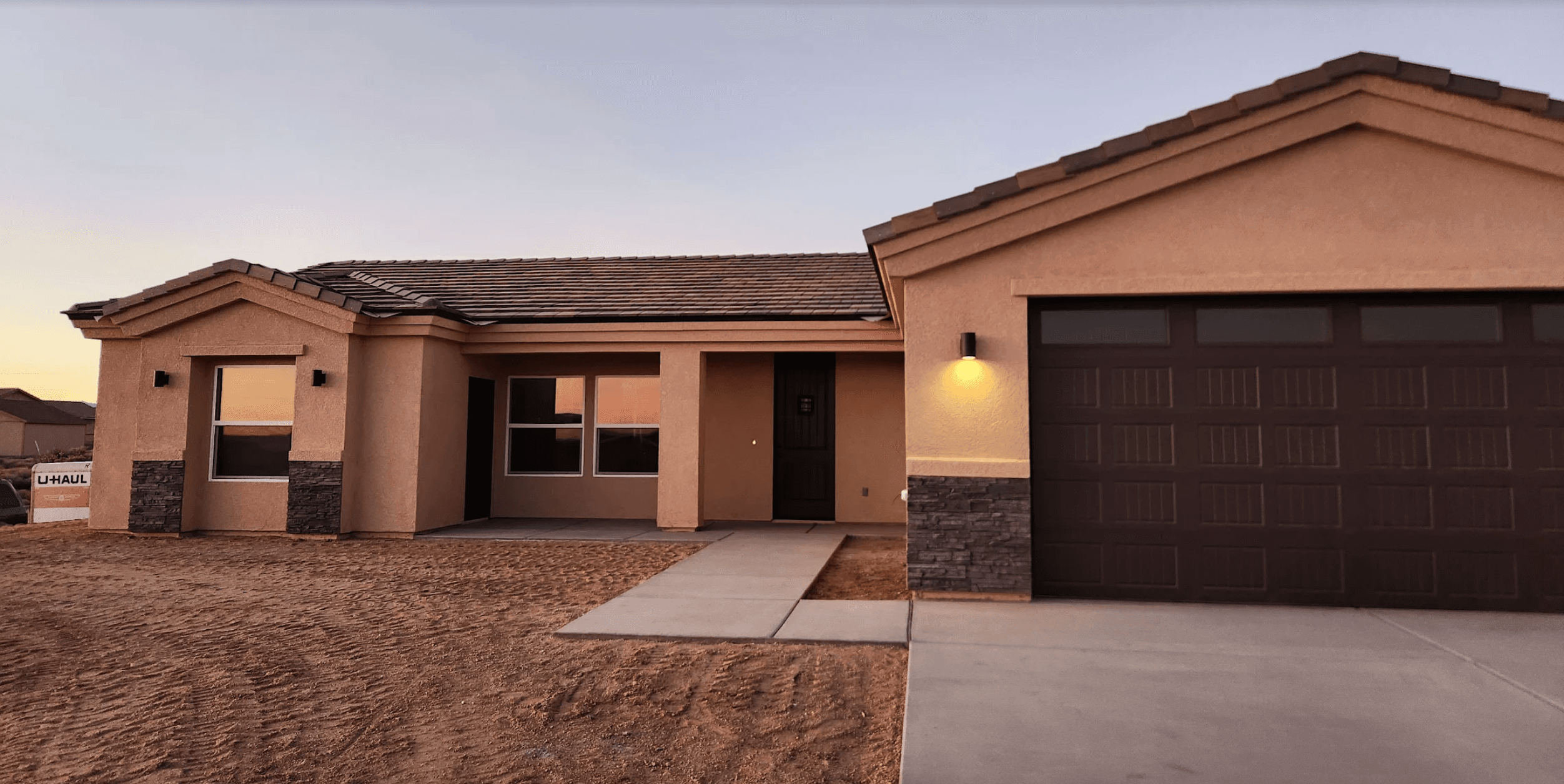 Exterior view of a completed custom home at golden hour